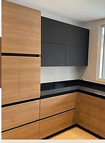 Cocina contemporánea de dos tonos: gabinetes en madera clara con altos en negro mate y tope negro.