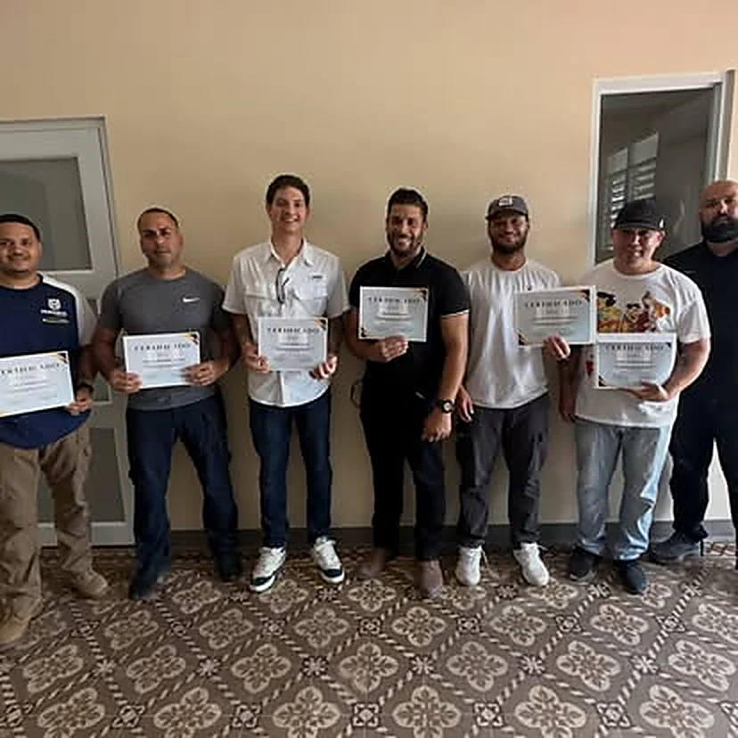 Grupo de siete estudiantes graduados posando con sus certificados de participación.